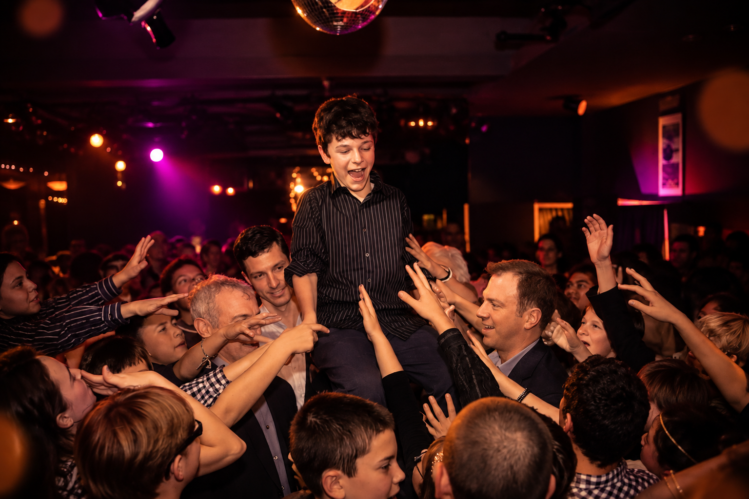 A kid lifted above the crowd on the dance floor